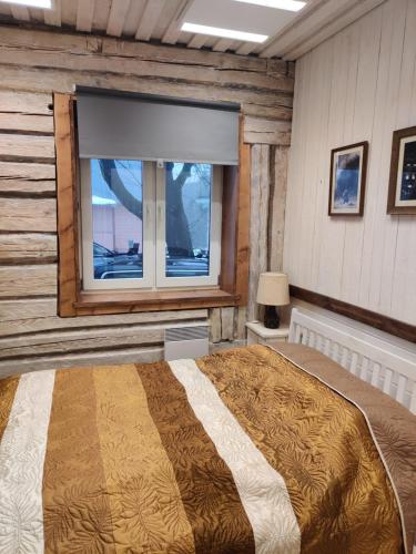 a bedroom with a large bed and a window at Ökopesa Külaliskorterid in Otepää