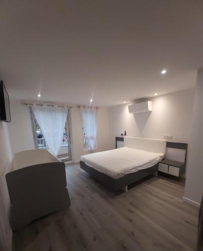 - une chambre blanche avec un lit et un canapé dans l'établissement Grand T3 piscine, garage centre port, au Cap d'Agde