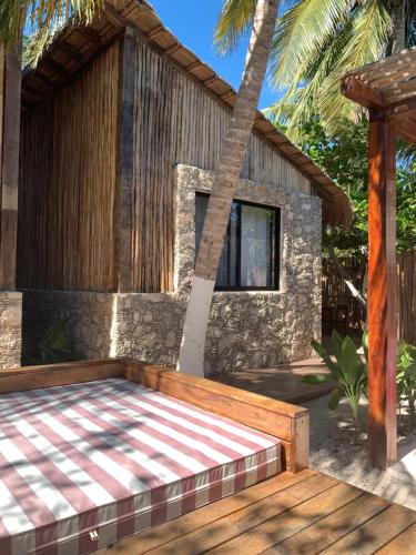 a house with a wooden deck in front of a building at Piña Coloradas Ecolodge in Yuluc