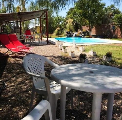 una mesa y sillas junto a una piscina en Shanti Hostel en San Rafael