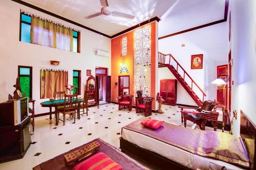a living room with a bed and a dining room at Indeco Hotels Swamimalai in Kumbakonam