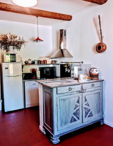 - une cuisine avec un îlot au milieu d'une pièce dans l'établissement La Colliassoise, à Collias