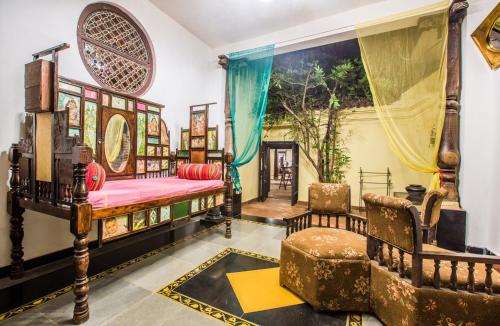 a room with a bed and a chair in it at Indeco Hotels Swamimalai in Kumbakonam