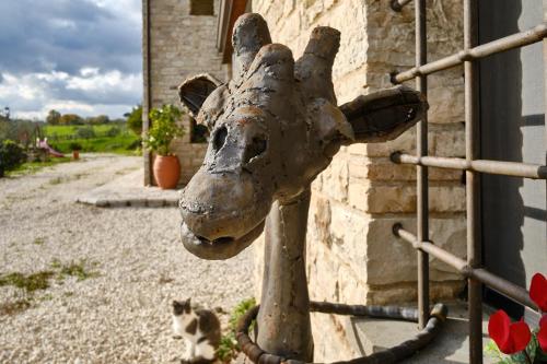 a statue of a giraffe next to a building with a cat at Monolocale di Campagna - LePietreBnB in Pietrelcina