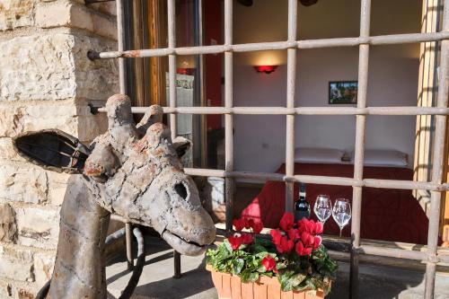 a statue of a giraffe next to a building with flowers at Monolocale di Campagna - LePietreBnB in Pietrelcina