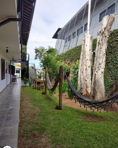 a hammock in the grass in front of a building at Shellter Hotel in Holambra