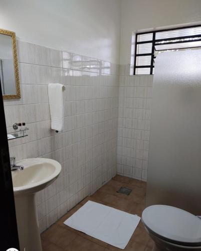 a bathroom with a toilet and a sink at Shellter Hotel in Holambra