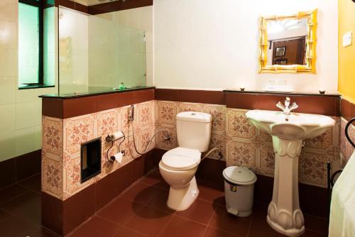 a bathroom with a toilet and a sink at Indeco Hotels Swamimalai in Kumbakonam