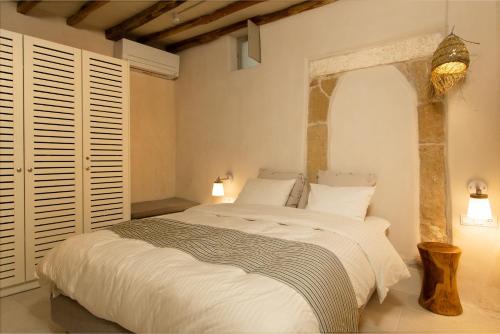 een slaapkamer met een groot bed met witte lakens bij Ariadne's Kastro Boutique Apartment in Naxos Chora