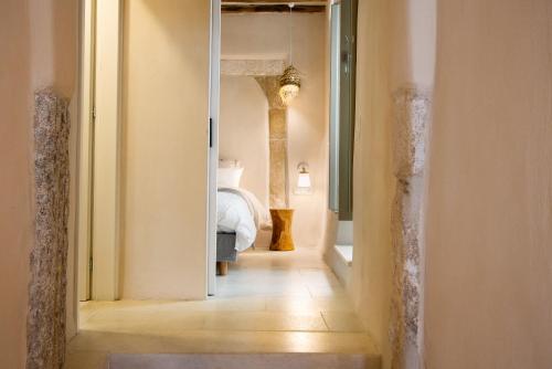 pasillo que conduce a un dormitorio con cama en Ariadne's Kastro Boutique Apartment, en Naxos Chora