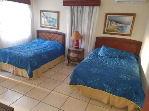 1 dormitorio con 2 camas y suelo de baldosa en Metro Country Club en Juan Dolio