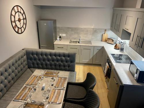 a kitchen with a couch and a table and a clock at Dunlap Apartments in Strabane
