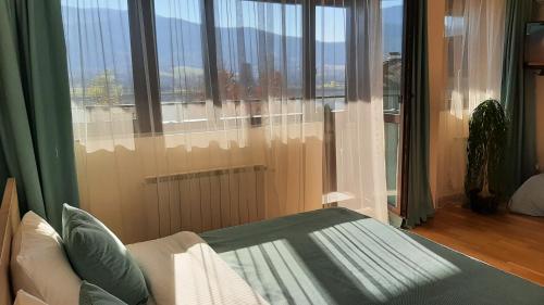 プラヴェツにあるStudio- apartament Lake View Pravets Golf Resortのベッドと大きな窓のある部屋