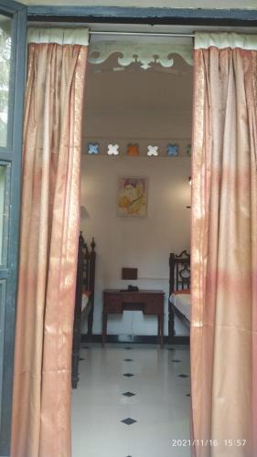 a room with curtains and a table in a room at Indeco Hotels Swamimalai in Kumbakonam