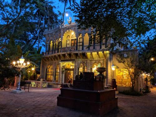 a building with a fountain in front of it at night at Indeco Hotels Swamimalai in Kumbakonam