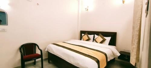 a bedroom with a bed and a red chair at Hotel Shannti Inn in Varanasi