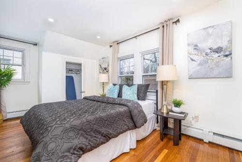 um quarto com uma cama grande e 2 janelas em Gorgeous 3 bedroom - 9 mins to Hartford, Connecticut em West Hartford