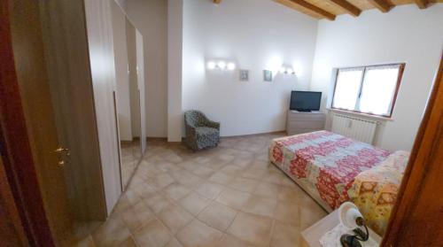 a bedroom with a bed and a window and a television at La casa del Re in Sipicciano