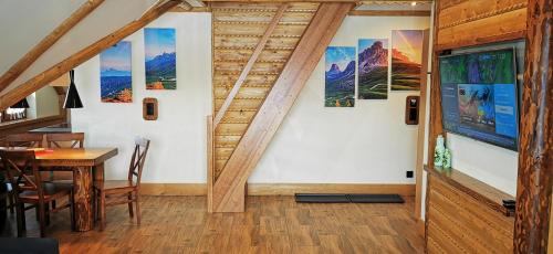 a dining room with a table and some pictures on the wall at Apartamenty Złoty Groń in Istebna
