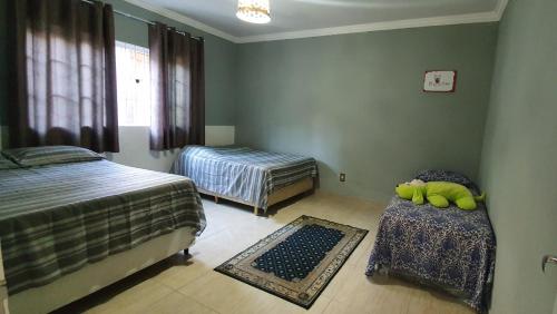 um quarto com 2 camas e uma mesa com uma cadeira em Recanto das Pretinhas em Ibiúna