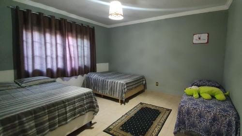 a bedroom with two beds and a couch and a window at Recanto das Pretinhas in Ibiúna