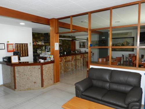 a living room with a couch and a bar at Hotel El Castell in Calafell