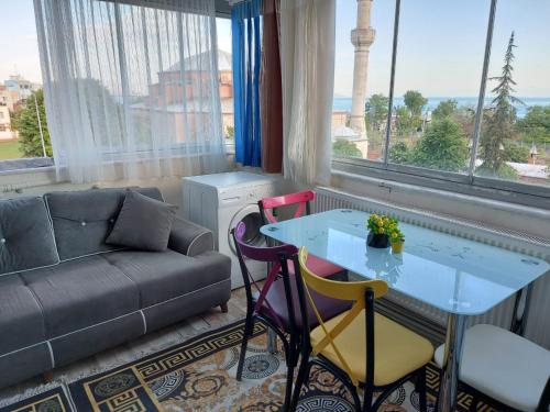 a living room with a couch and a table and chairs at Apart La Mia in Istanbul
