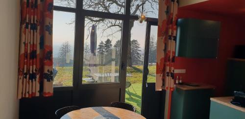 a kitchen with a table and a large window at Le Domaine de Dony in Balbins