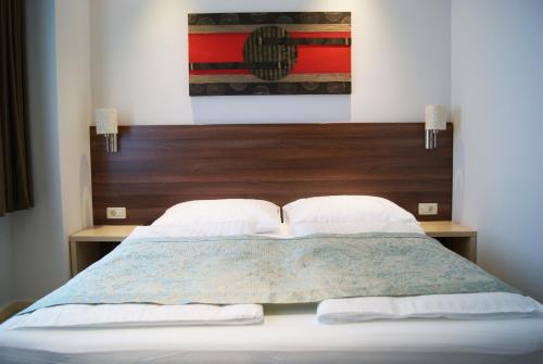 a bedroom with a bed with a wooden headboard at Boutique Hotel Ukus in Tešanj