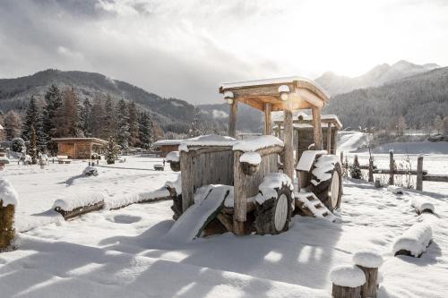 a wooden toy truck in the snow with a tower at Aparthotel Familiaris - Family Apartments - Pools & Spa in Dolomites in Valdaora