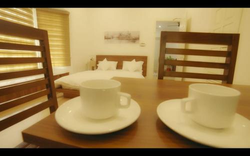 duas chávenas e pires numa mesa num quarto em BROOKLANDS AVENUE em Alappuzha