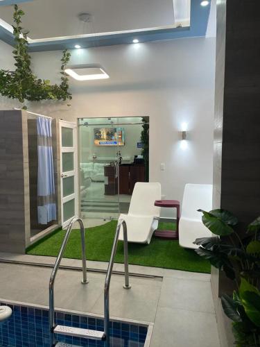 a bathroom with two white chairs and a sink at Hotel Andy in Atacames