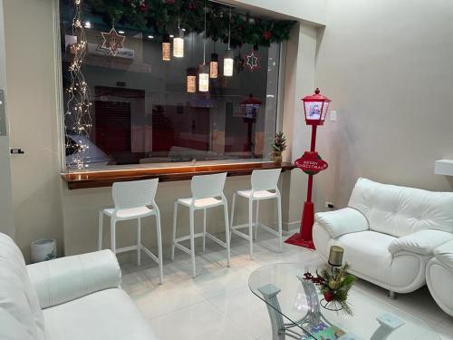 a living room with a couch and chairs and a counter at Hotel Andy in Atacames