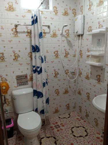 a bathroom with a toilet and a shower and a sink at บุญจินดา รีสอร์ท in Ban Phayom