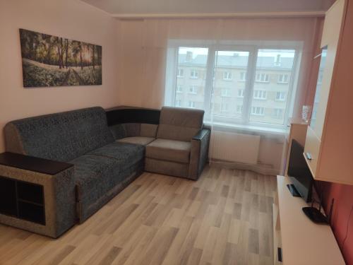 a living room with a couch and a chair at VA Apartments in Rēzekne