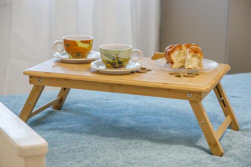 una mesa de madera con dos tazas y pan. en 4 Seasons villa-Sea view en Hersonissos