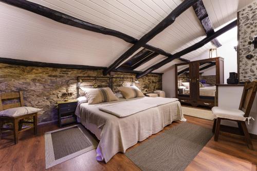 a bedroom with a bed and a stone wall at Casa Brandariz in Santa Maria de Arzua