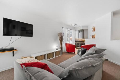 sala de estar con sofá y TV de pantalla plana en INITIAL - LE REPOS DES SKIEURS - Mont-Sainte-Anne, en Saint-Férréol-les-Neiges