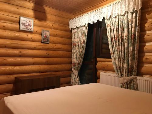 a bedroom with a bed in a log cabin at Cottage Lavanda окремий котедж з каміном in Bukovel