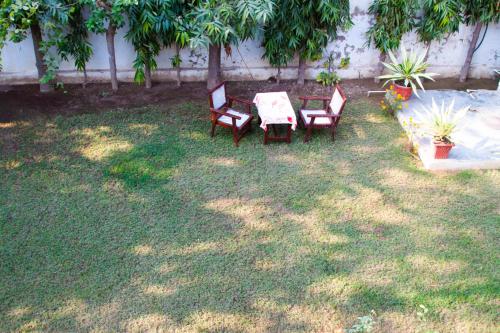 a patio with two chairs and a table in a yard at Falcon guest house in Bharatpur