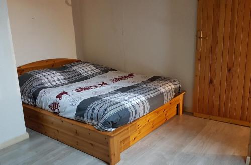 a bed with a wooden frame in a room at Le Duplex Septimontain in Samoëns