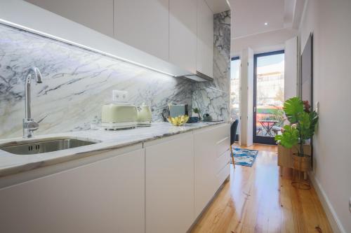a kitchen with white cabinets and a sink at THE TWIN Apartments in Porto