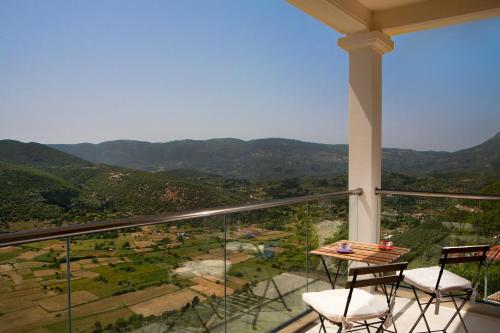 a balcony with two chairs and a table with a view at Heavenly Heights Villas By KB Hospitality in Évyiros