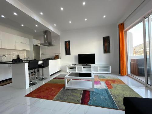 una sala de estar con una alfombra colorida en el suelo en Duarte Apartments - Laginha, en Mindelo