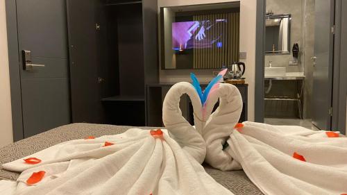 two towel swans sitting on a bed in a bathroom at Antik Houses in Istanbul