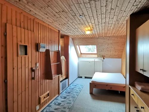 um pequeno quarto com uma cama e um tecto de madeira em Rafael Kaiser Residence Privée - Spielberg Obdach em Obdach