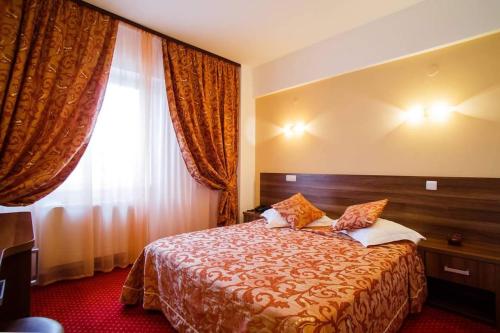 um quarto de hotel com uma cama e uma janela em Hotel Premier Botosani em Botoşani