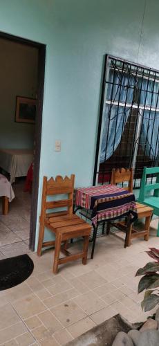 a room with two chairs and a table and a bench at Cabinas Mitchaelle's in Puerto Viejo