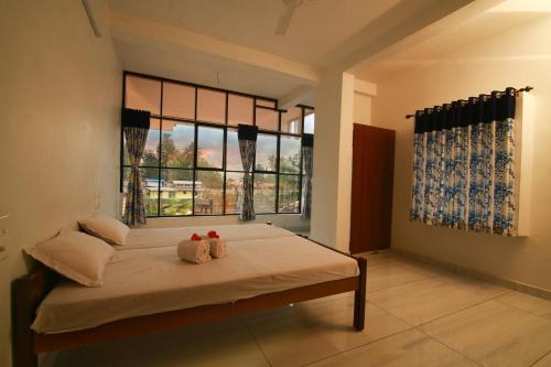a bedroom with a bed with two stuffed animals on it at Royal Holidays in Alleppey