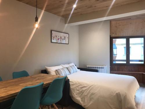 a bedroom with a bed and a table and chairs at Apartamento de Alicia in Betrén